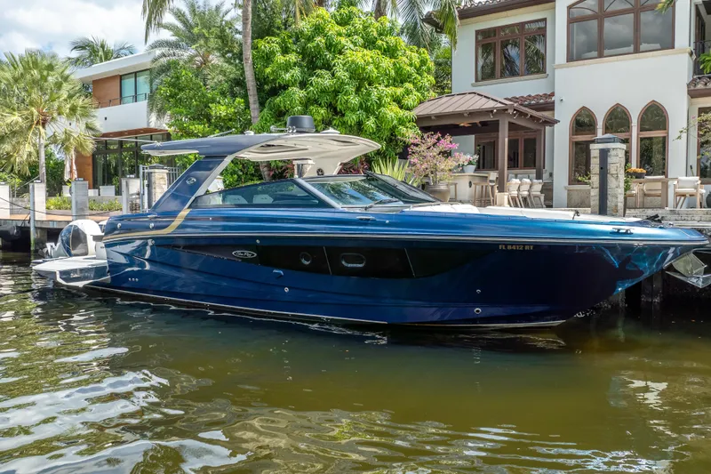 Yacht Photos Pics 2019 Sea Ray SLX 400 Outboard boat docked by a luxurious waterfront home.