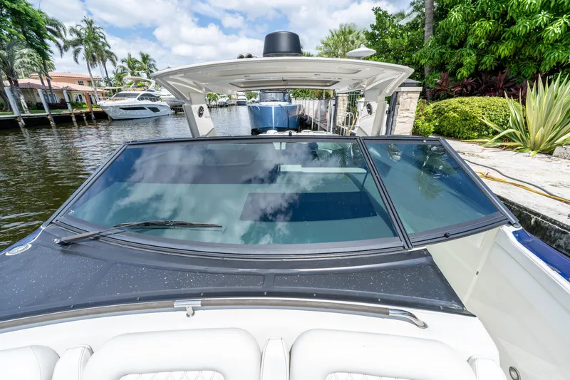  Yacht Photos Pics 2019 Sea Ray SLX 400 Outboard boat docked by lush greenery and waterfront homes.