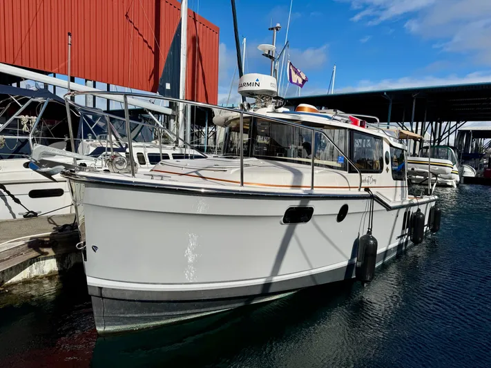  Yacht Photos Pics 2024 Ranger Tugs R-27 boat docked at a marina, featuring a sleek white exterior.