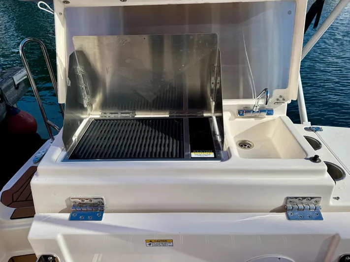  Yacht Photos Pics Outdoor grill and sink on 2024 Ranger Tugs R-27 boat, docked by water.