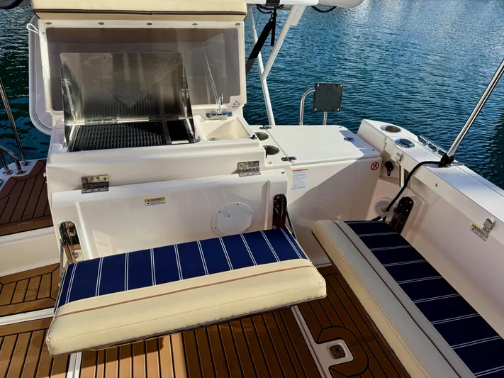  Yacht Photos Pics 2024 Ranger Tugs R-27 boat interior with seating and grill, docked on water.