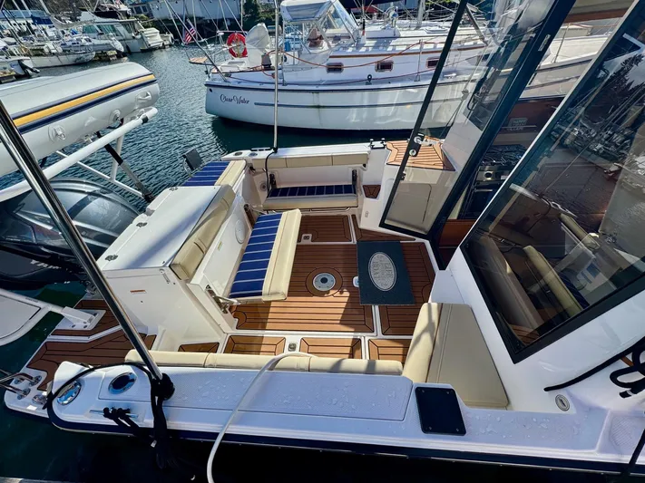  Yacht Photos Pics 2024 Ranger Tugs R-27 boat interior with seating and wood flooring at a marina.