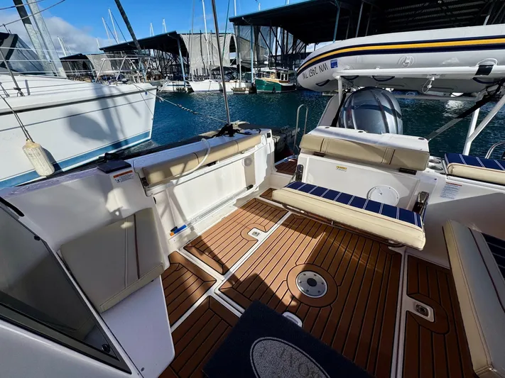  Yacht Photos Pics 2024 Ranger Tugs R-27 boat interior with teak flooring and seating at a marina.