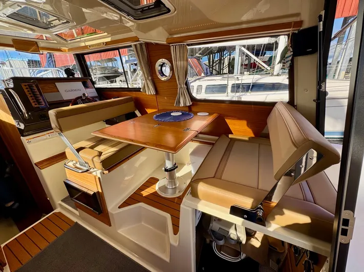  Yacht Photos Pics 2024 Ranger Tugs R-27 interior with dining area, wood accents, and large windows.