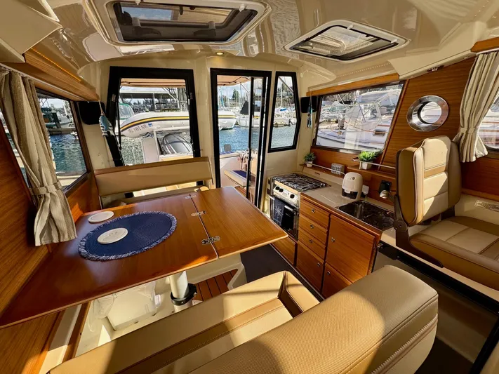  Yacht Photos Pics 2024 Ranger Tugs R-27 interior with dining area, kitchenette, and marina view.