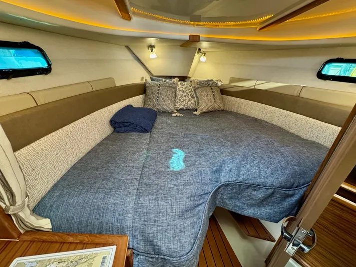  Yacht Photos Pics 2024 Ranger Tugs R-27 cabin interior with cozy bed and ambient lighting.
