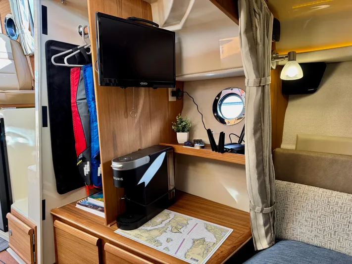  Yacht Photos Pics 2024 Ranger Tugs R-27 interior with TV, coffee maker, and nautical map.