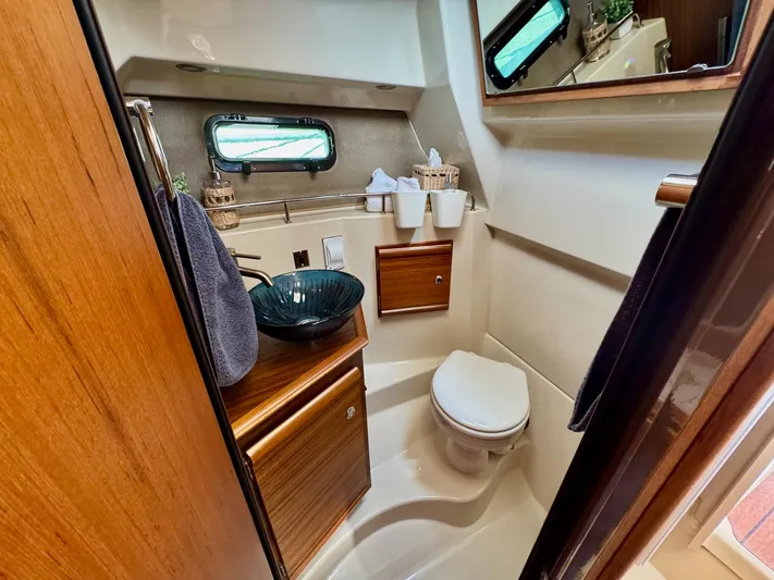  Yacht Photos Pics 2024 Ranger Tugs R-27 bathroom with modern amenities and elegant wood finishes.