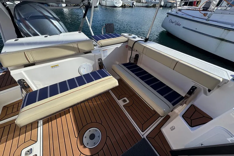  Yacht Photos Pics 2024 Ranger Tugs R-27 boat interior with cushioned seating and teak flooring.