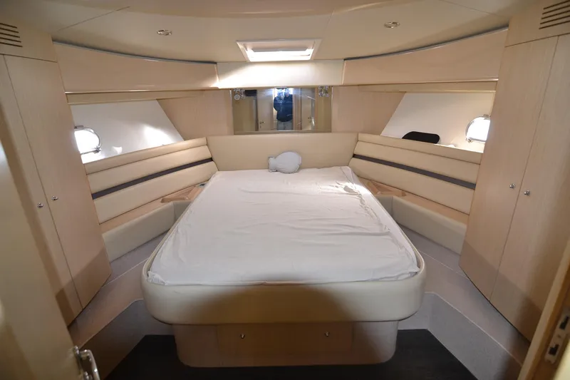 Yacht Photos Pics Luxurious bedroom interior of 2006 Ferretti Yachts 550 with elegant wood finishes.