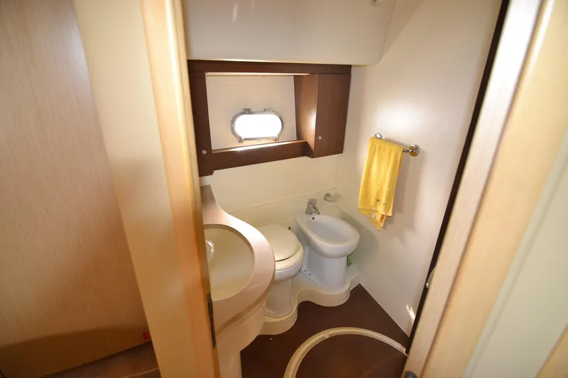  Yacht Photos Pics Bathroom interior of 2006 Ferretti Yachts 550, featuring modern fixtures and a porthole window.