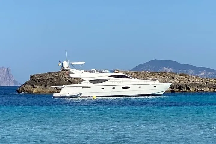  Yacht Photos Pics 2006 Ferretti Yachts 550 cruising near rocky island in clear blue waters.