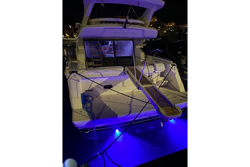  Yacht Photos Pics Luxury 2006 Ferretti Yachts 550 docked at night with blue underwater lights.