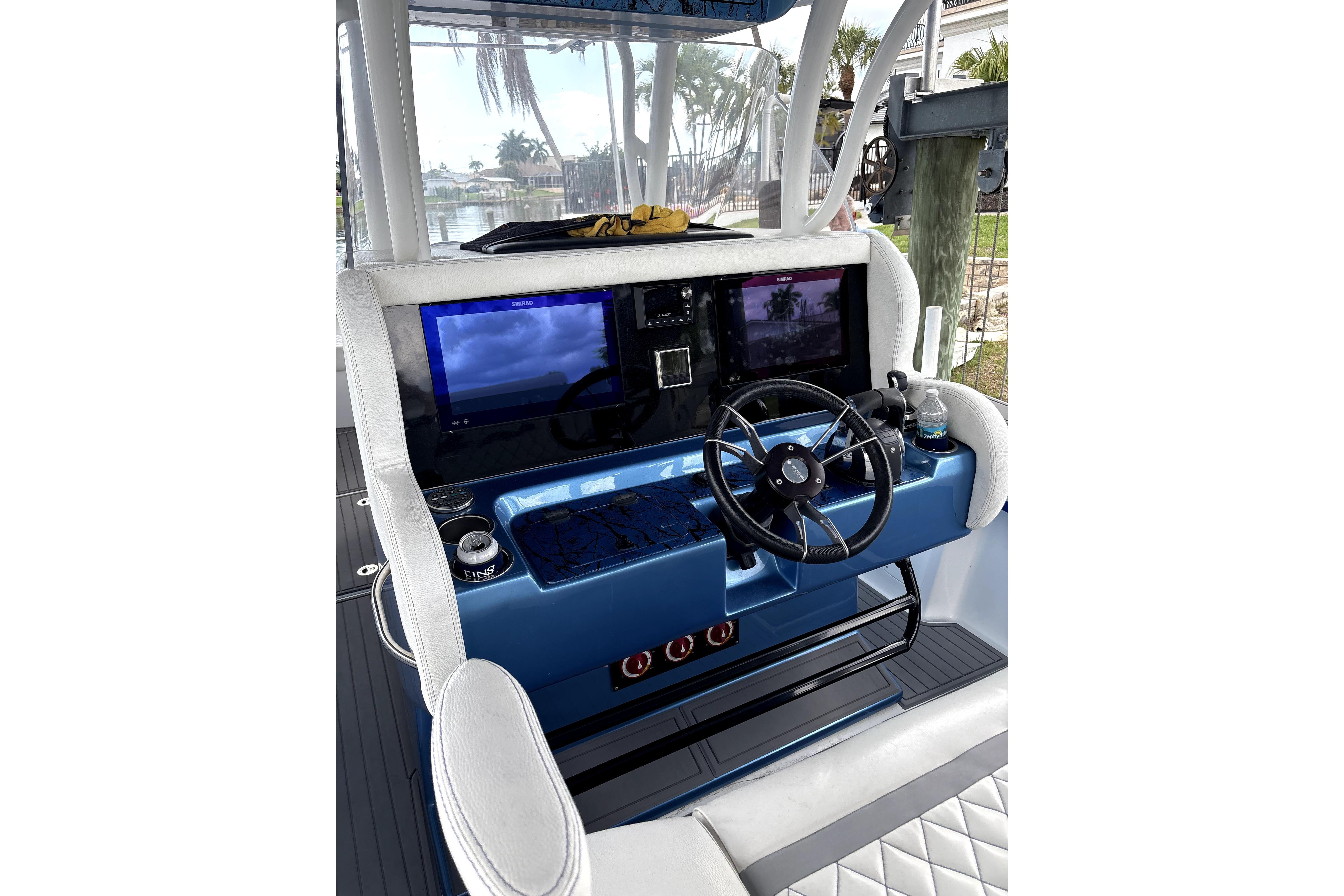 2019 Statement Fishing Edition boat dashboard with steering wheel and navigation screens.