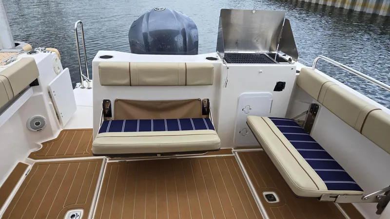  Yacht Photos Pics 2021 Ranger Tugs R-25 boat interior with seating and grill, docked by the water.