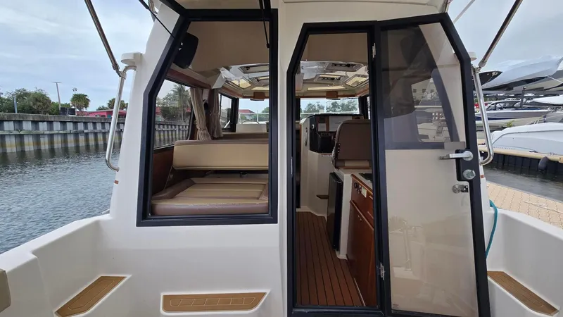  Yacht Photos Pics 2021 Ranger Tugs R-25 interior view, showcasing cabin and seating area by the water.