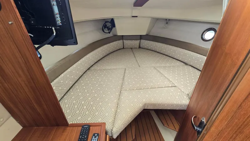  Yacht Photos Pics 2021 Ranger Tugs R-25 cabin interior with cushioned seating and wooden accents.