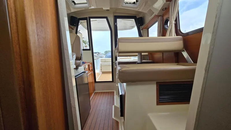  Yacht Photos Pics Interior view of 2021 Ranger Tugs R-25 boat, featuring seating and wooden flooring.