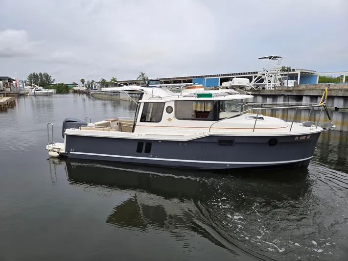  Yacht Photos Pics 2021 Ranger Tugs R-25 boat on calm water near a marina.