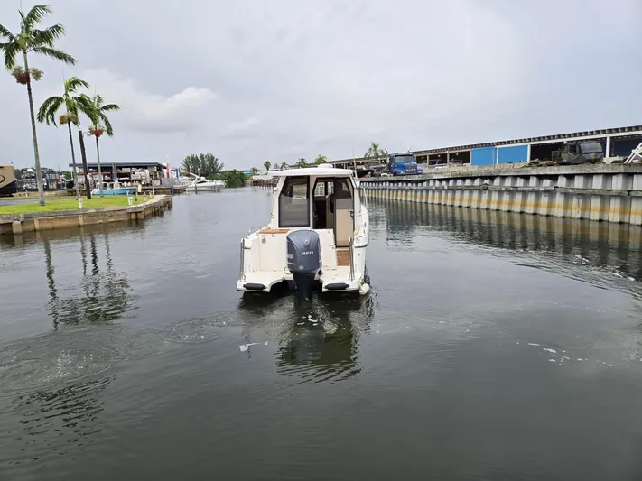  Yacht Photos Pics 2021 Ranger Tugs R-25 boat navigating a calm marina with palm trees.