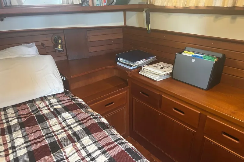  Yacht Photos Pics Cozy cabin interior of 1996 Grand Banks 36 Motoryacht with wood paneling and plaid bedding.