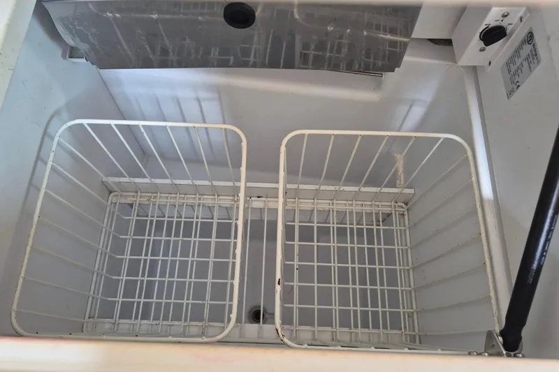 Misty Yacht Photos Pics Empty freezer compartment with wire baskets on Jeanneau Sun Odyssey 519, 2018 model.