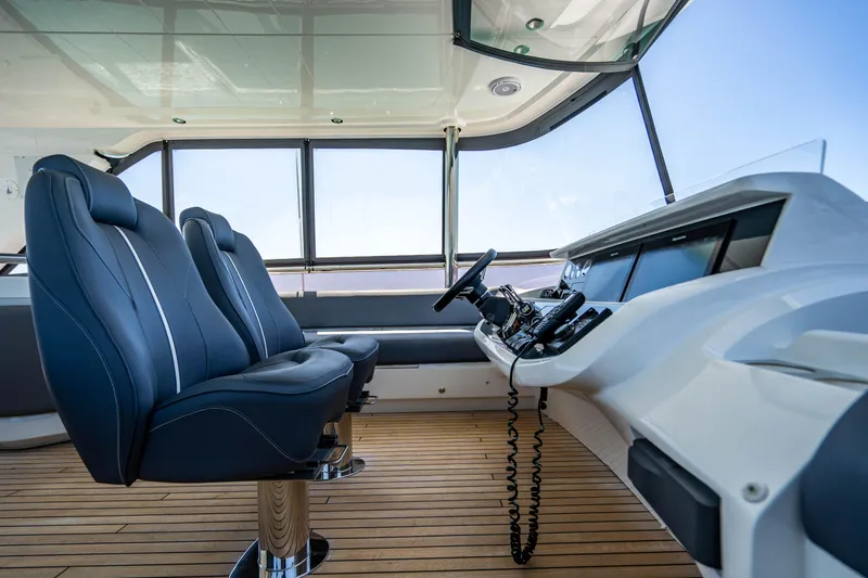 Comfortably Numb Yacht Photos Pics Interior helm of 2018 Princess Y75 Motor Yacht with leather seats and modern controls.