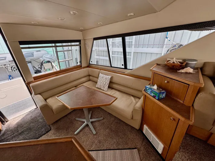 The Journey Yacht Photos Pics Interior of 1999 Bayliner 3988 Command Bridge Motoryacht with cozy seating and wooden cabinetry.