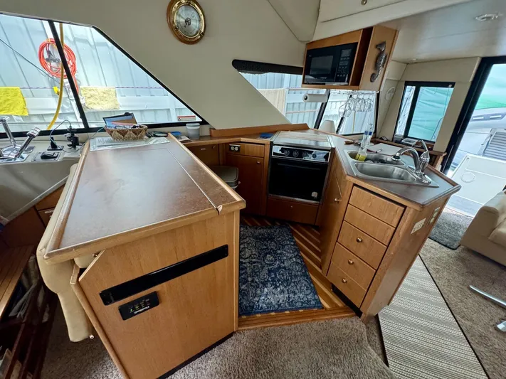 The Journey Yacht Photos Pics 1999 Bayliner 3988 Command Bridge Motoryacht interior with kitchen, sink, and wooden cabinetry.