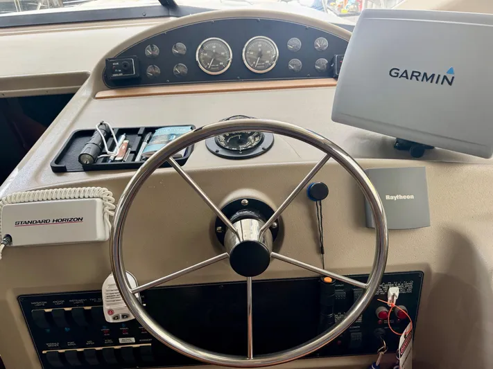 The Journey Yacht Photos Pics 1999 Bayliner 3988 Command Bridge Motoryacht helm with Garmin and Raytheon navigation systems.