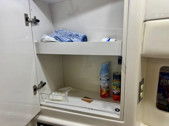 The Journey Yacht Photos Pics Cabinet interior on 1999 Bayliner 3988 yacht with cleaning supplies and towels.