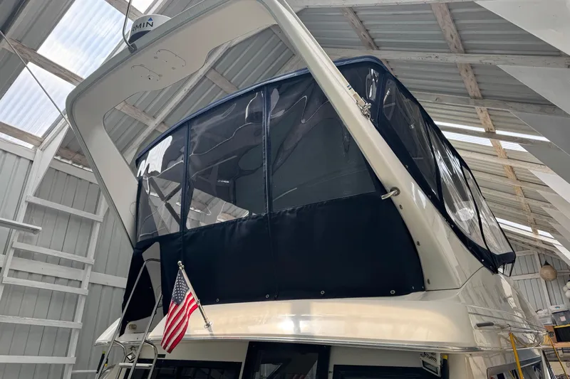The Journey Yacht Photos Pics 1999 Bayliner 3988 Command Bridge Motoryacht in a covered dock with American flag.