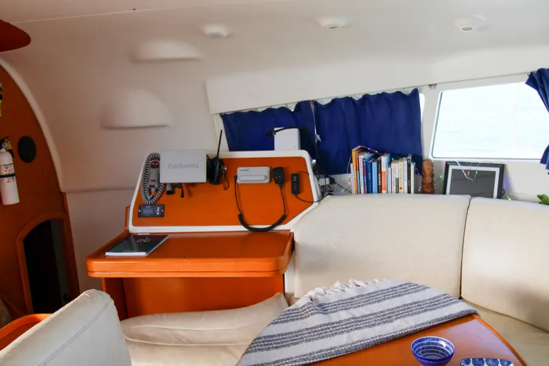 One Life Yacht Photos Pics Interior of 2002 Lagoon 410 catamaran with navigation station and cozy seating area.