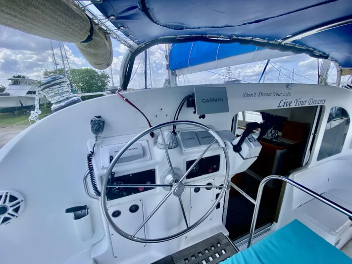 One Life Yacht Photos Pics Cockpit of 2002 Lagoon 410 catamaran with steering wheel and navigation equipment.