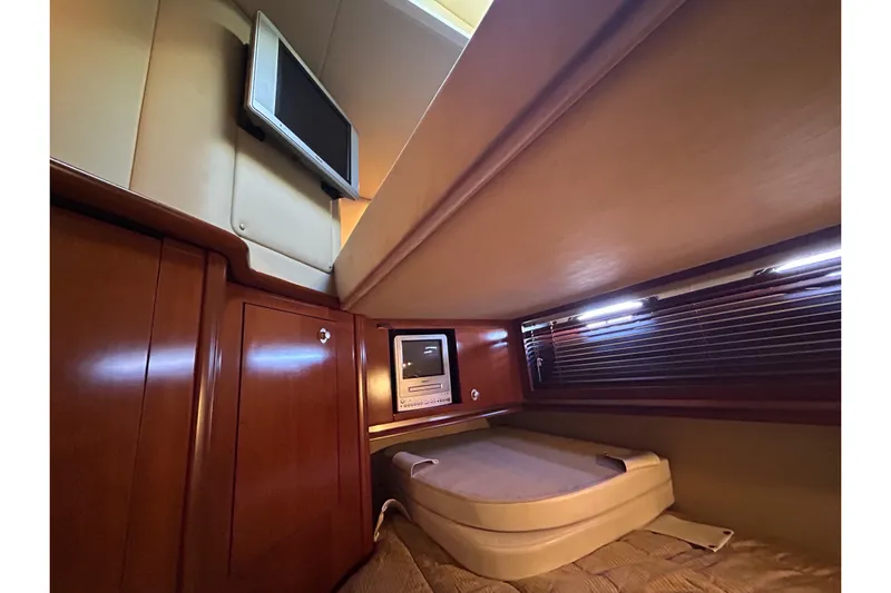 Blue Diamond Yacht Photos Pics 2005 Sea Ray 500 Sundancer cabin interior with TV and wooden cabinetry.