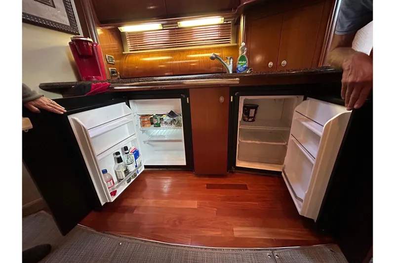 Blue Diamond Yacht Photos Pics 2005 Sea Ray 500 Sundancer kitchen with open mini-fridges and wooden flooring.