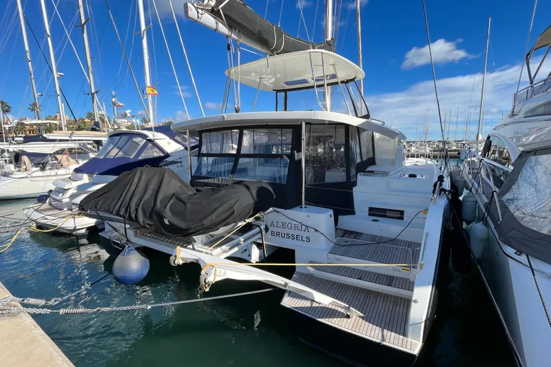 Alegr&iacute;a Yacht Photos Pics 2020 Lagoon 46 catamaran docked in a marina, sunny day, clear blue sky.