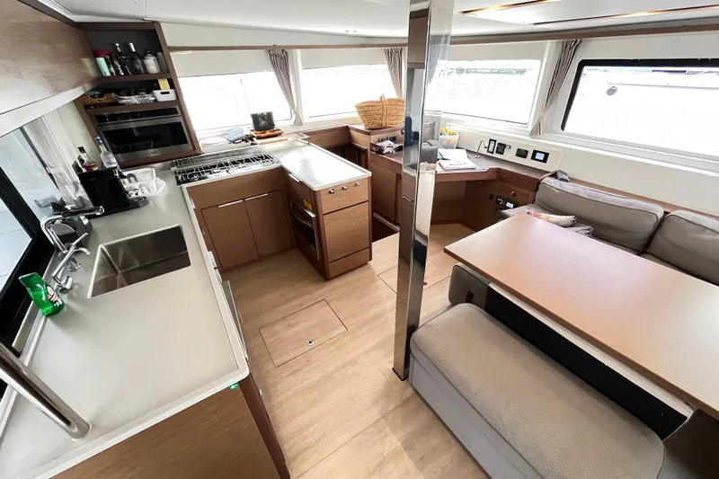Alegr&iacute;a Yacht Photos Pics Modern interior of 2020 Lagoon 46 catamaran featuring kitchen and dining area.