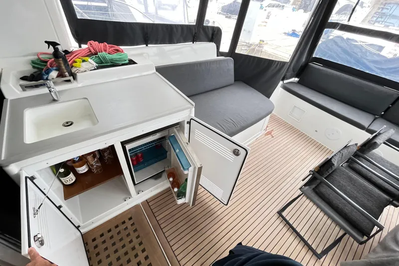 Alegr&iacute;a Yacht Photos Pics Interior of 2020 Lagoon 46 yacht with kitchenette, seating, and wooden flooring.