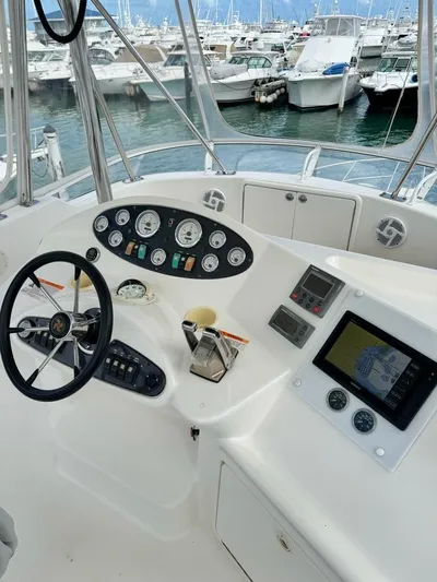  Yacht Photos Pics 2004 Riviera 37 Convertible yacht helm with gauges and navigation equipment, docked at marina.