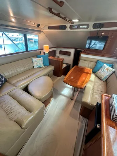  Yacht Photos Pics Luxurious interior of 2004 Riviera 37 Convertible yacht with plush seating and wooden table.