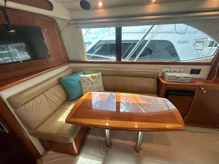  Yacht Photos Pics Luxurious interior of 2004 Riviera 37 Convertible yacht with leather seating and wooden table.