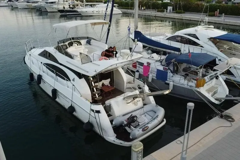 Nina Yacht Photos Pics 2000 Azimut 52 yacht docked at marina, featuring spacious deck and modern design.