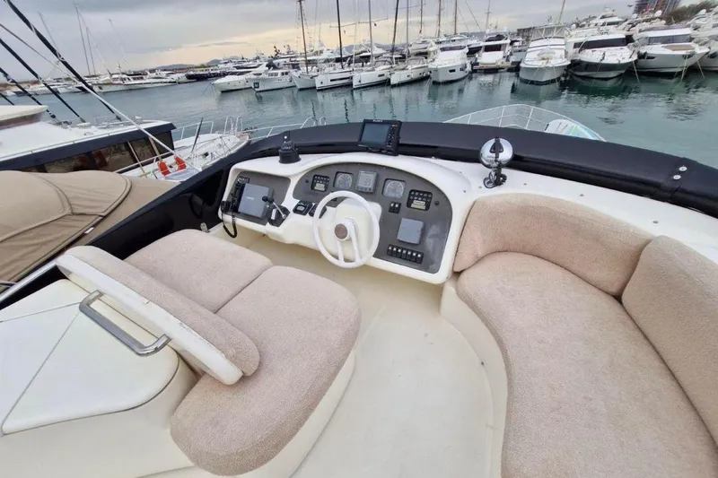 Nina Yacht Photos Pics Cockpit of a 2000 Azimut 52 yacht with beige seating, docked in a marina.