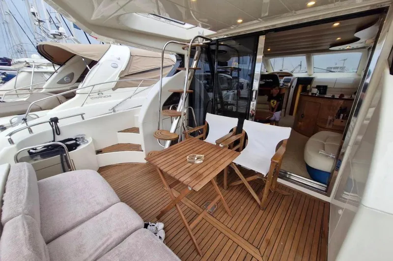 Nina Yacht Photos Pics Luxurious 2000 Azimut 52 yacht interior with wooden deck and seating area.