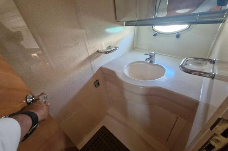 Nina Yacht Photos Pics Bathroom interior of a 2000 Azimut 52 yacht, featuring a sink and porthole window.