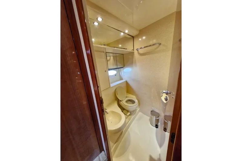 Nina Yacht Photos Pics Bathroom interior of 2000 Azimut 52 yacht, featuring toilet, sink, and mirror.