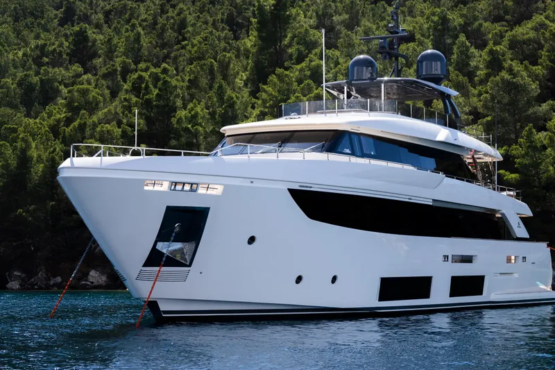 Sk Yacht Photos Pics Luxurious 2019 Custom Line Navetta 33 yacht anchored near lush green forest.