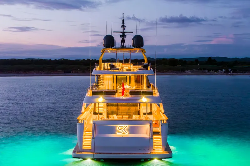 Sk Yacht Photos Pics Luxurious 2019 Custom Line Navetta 33 yacht illuminated at dusk on tranquil waters.