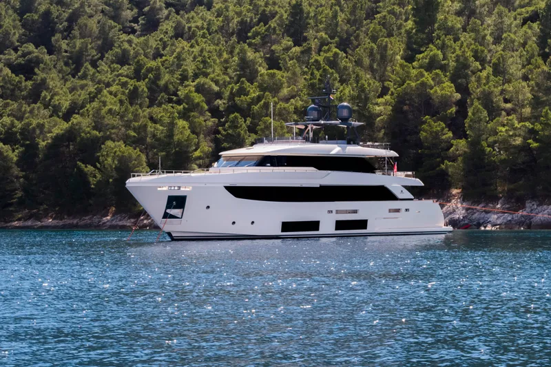 Sk Yacht Photos Pics Luxurious 2019 Custom Line Navetta 33 yacht anchored near lush green forest.